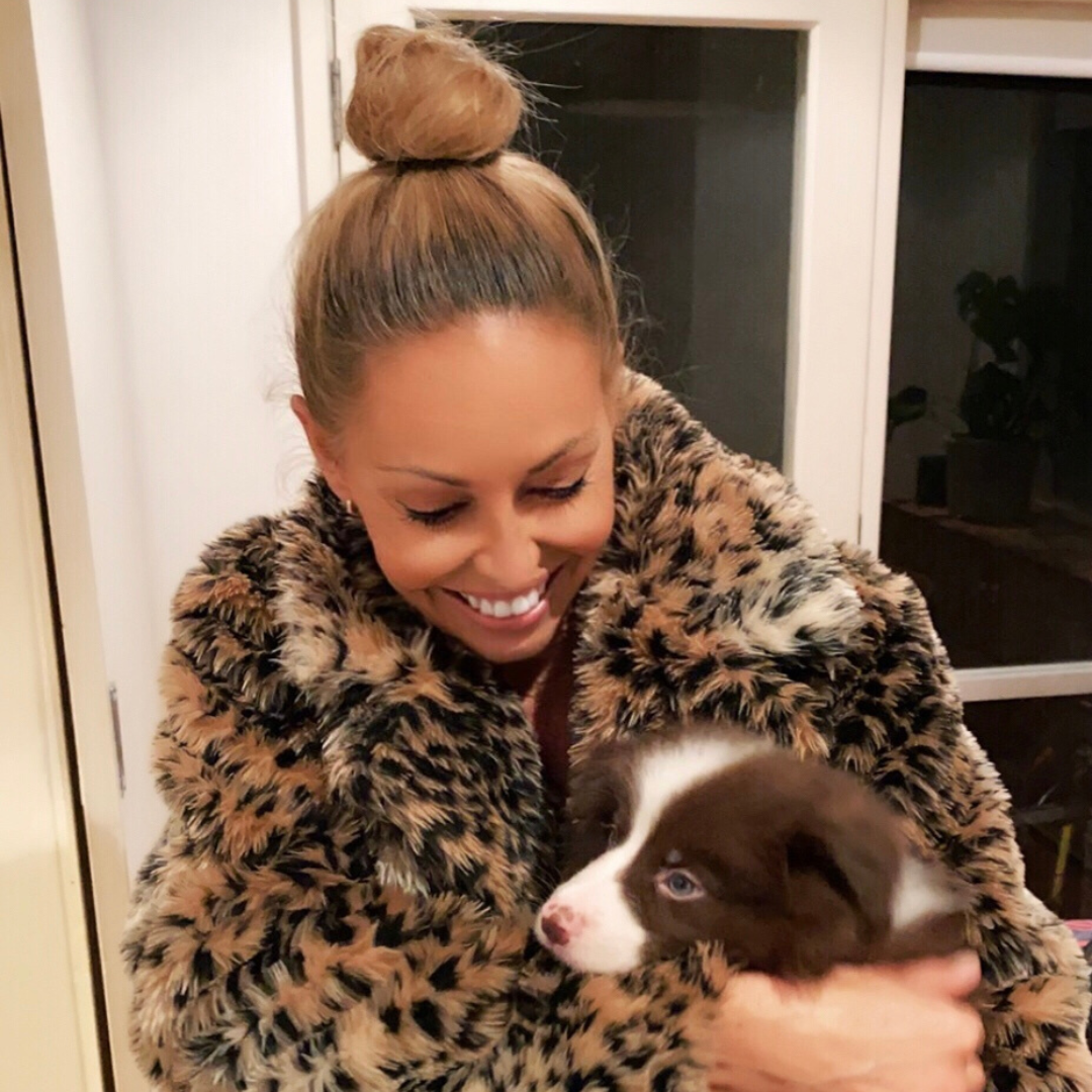 women holding a cute dog while smiling