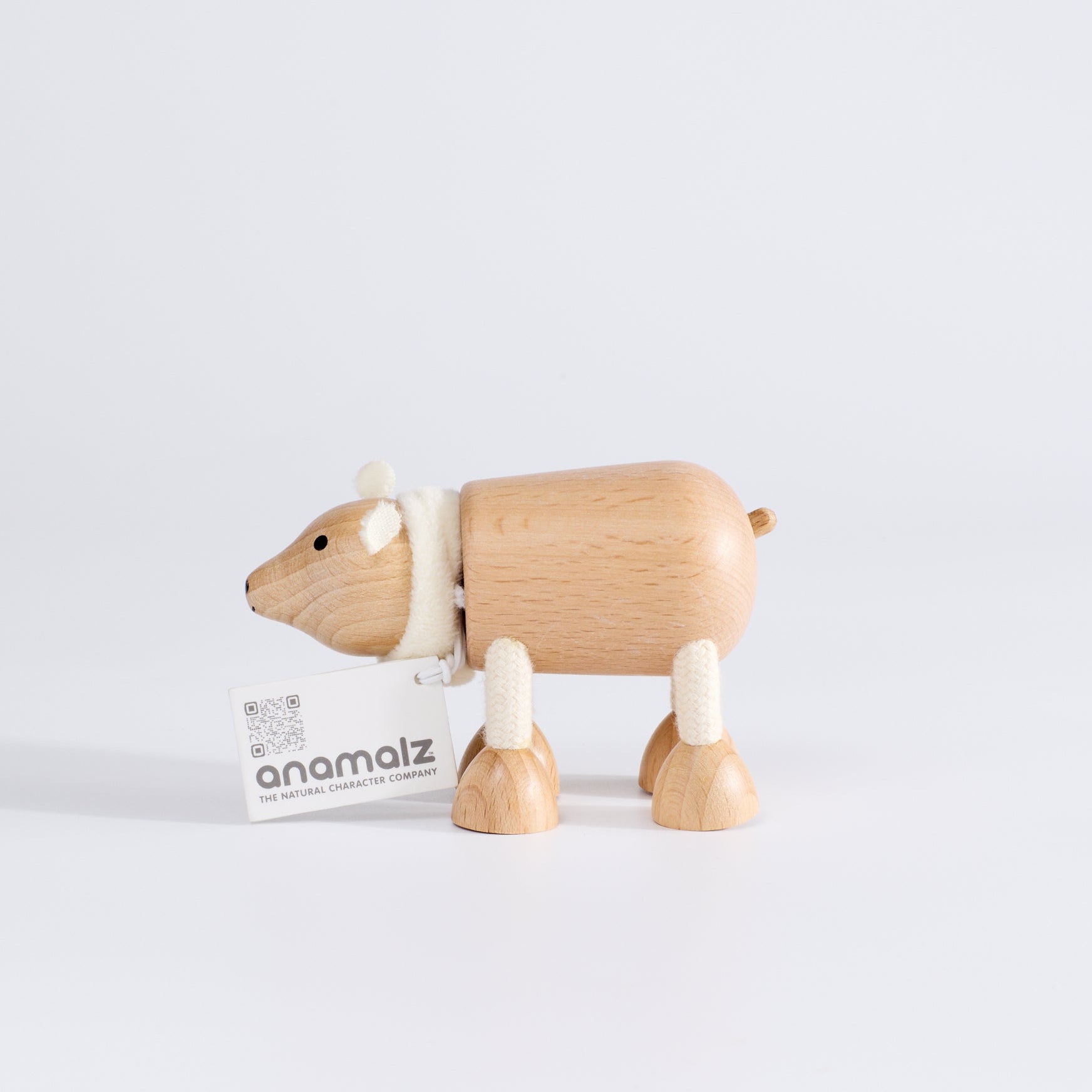 A wooden polar bear toy facing sideways, standing upright on a white background.