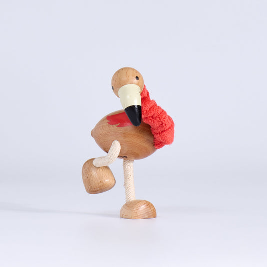 Wooden flamingo figurine on a light gray background