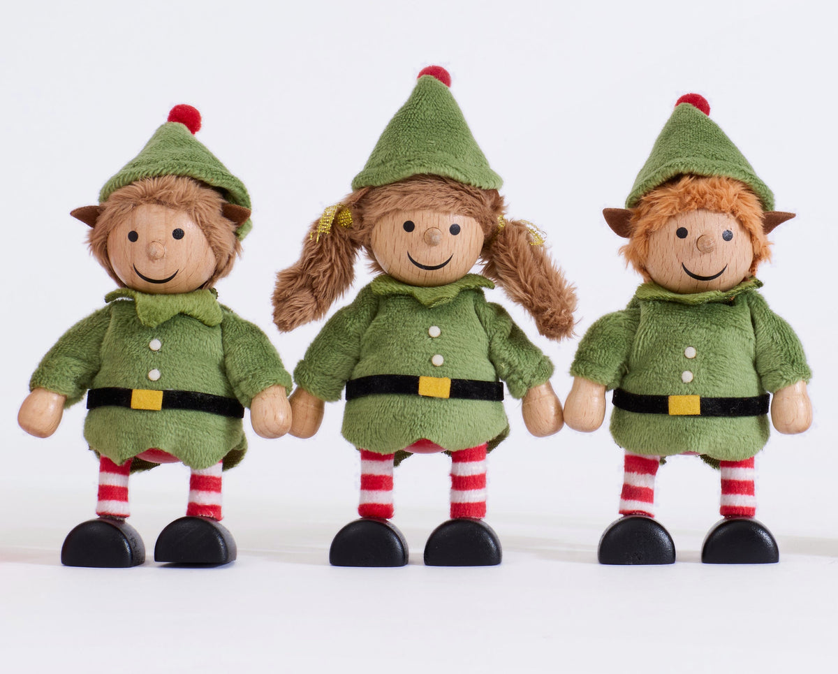 Close-up of the three Cheeky Elves showing their wooden faces, green outfits and striped legs