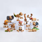 A collection of wooden animal figures including representations of a cow, pig, horse, dog, crocodile, lion, elephant, giraffe, sheep, echidna, kangaroo, and zebra.