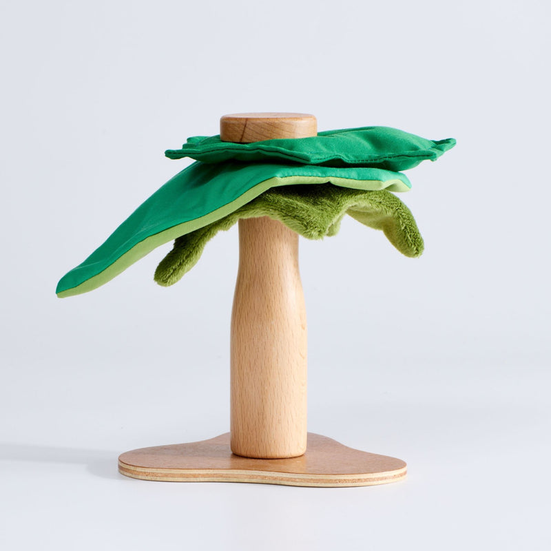 A wooden toy tree with a green plush canopy on a sturdy wooden base