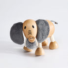 Wooden toy elephant with gray trunk and ears on a white background