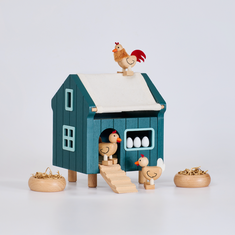 Toy chicken coop with chickens and eggs on a white background