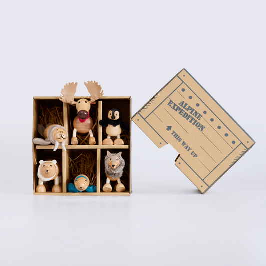 Wooden toy animals on a wooden crate with 'Alpine Expedition' text on a light gray background