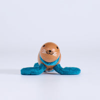 Small wooden toy  seal with a face and blue string on a white background
