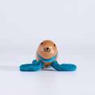Small wooden toy  seal with a face and blue string on a white background