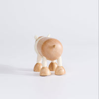A wooden polar bear toy facing backwards, standing upright on a white background.