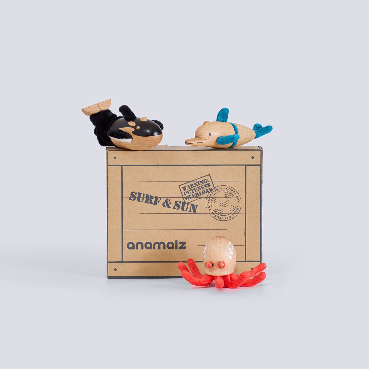 Toy figures on a cardboard box with 'anamalz' branding on a light gray background
