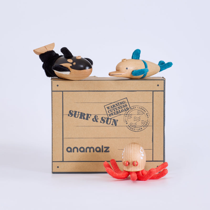 Toy figures on a cardboard box with 'anamalz' branding on a light gray background