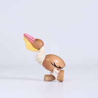 Wooden pelican toy on a light gray background