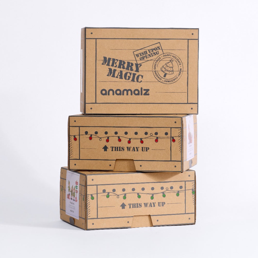 Three anamalz Christmas gift boxes stacked to show Merry Magic lettering and festive string-light designs